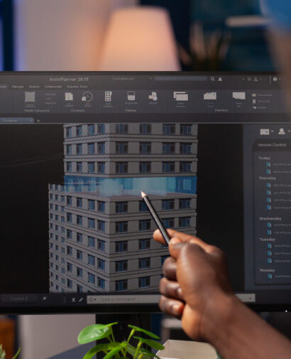 Architect engineer pointing at architectural building prototype analyzing construction model on computer. Businessman designer working remote from home at real estate project modeling sketch